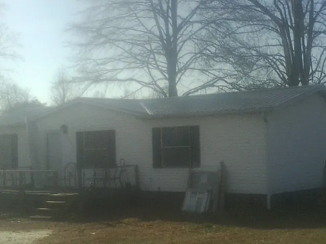 New metal roof on a white painted brick home on a foggy morning in Johnstown
