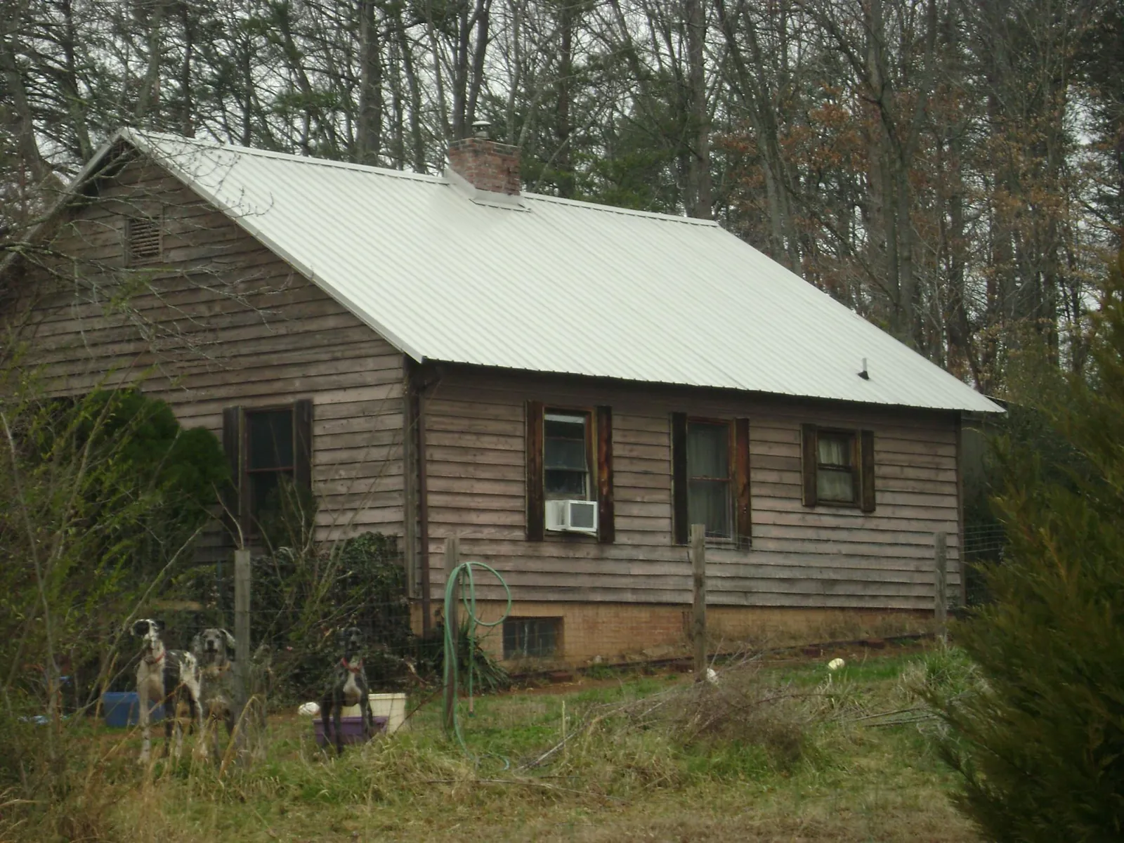 White metal roof on an old wood sided farmhouse, from a Asphalt Shingle Roof Repair job in Johnstown